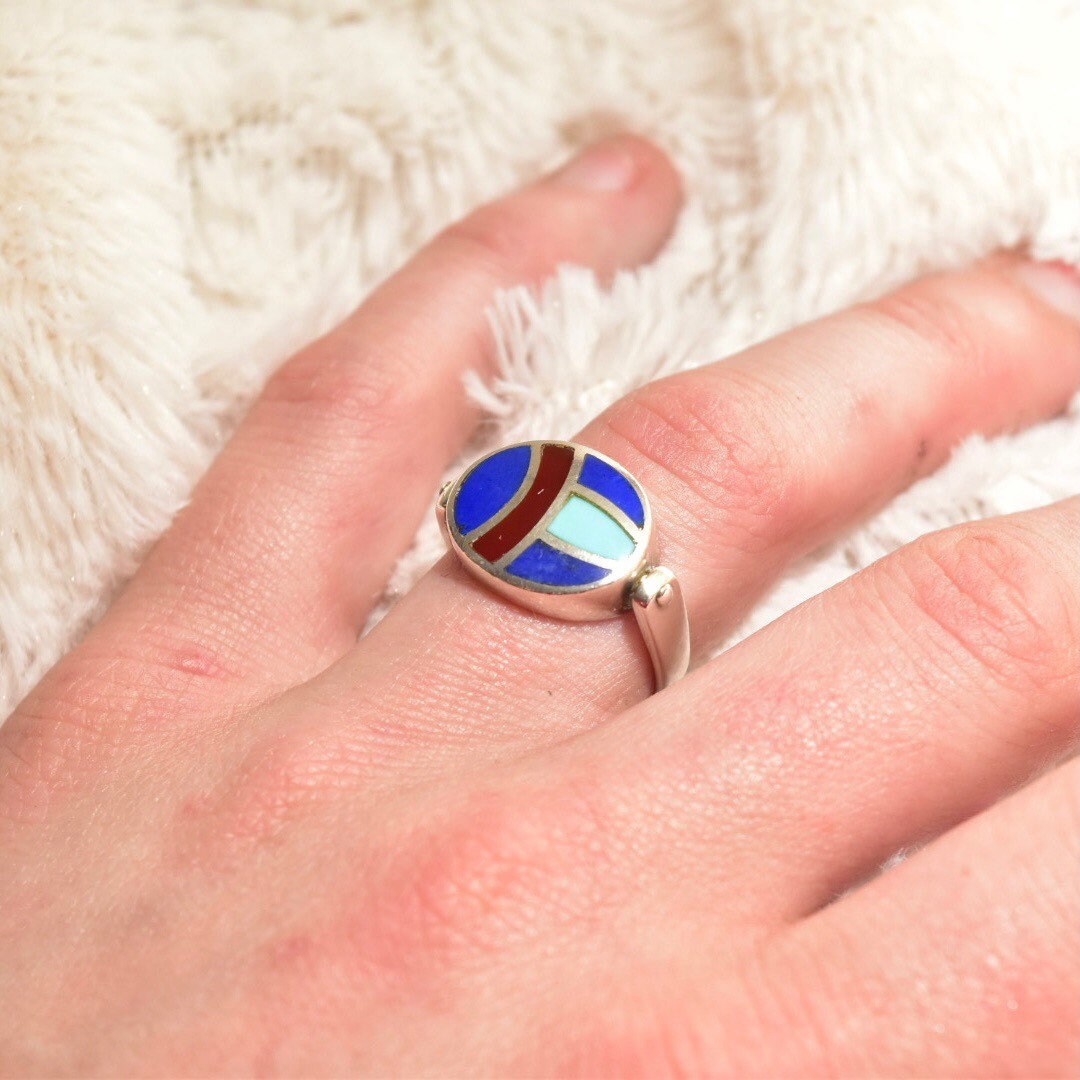 Vintage sterling silver flip ring with lapis lazuli, turquoise, and carnelian inlay, worn on finger