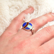 Vintage sterling silver flip ring with lapis lazuli, turquoise, and carnelian inlay, worn on finger
