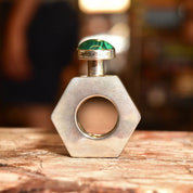 Alt text: Vintage TAXCO modernist sterling silver mini hexagonal perfume bottle with malachite top, 2 inches tall, sitting on wooden surface