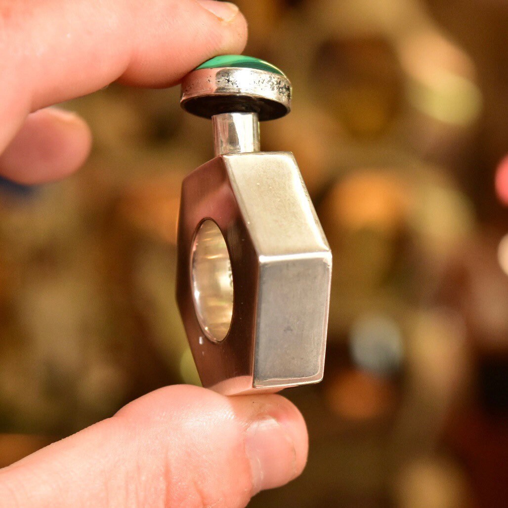 Vintage TAXCO modernist sterling silver perfume bottle with malachite top, held in hand to show detail of hexagonal shape and size. Mini perfume bottle measures approximately 2 inches tall, marked TA-187 Mexico.