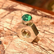 Sterling silver hexagonal perfume bottle with malachite green stone top, modernist vintage design from Taxco, Mexico, measuring 2 inches tall, on textured marble surface