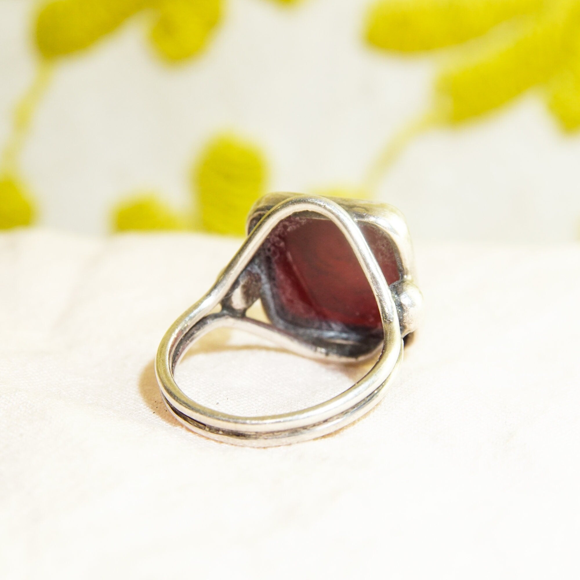 Sterling silver ring with carved black agate intaglio seal depicting a Roman warrior cameo, men's pinky ring size 6 US, shown on floral yellow background