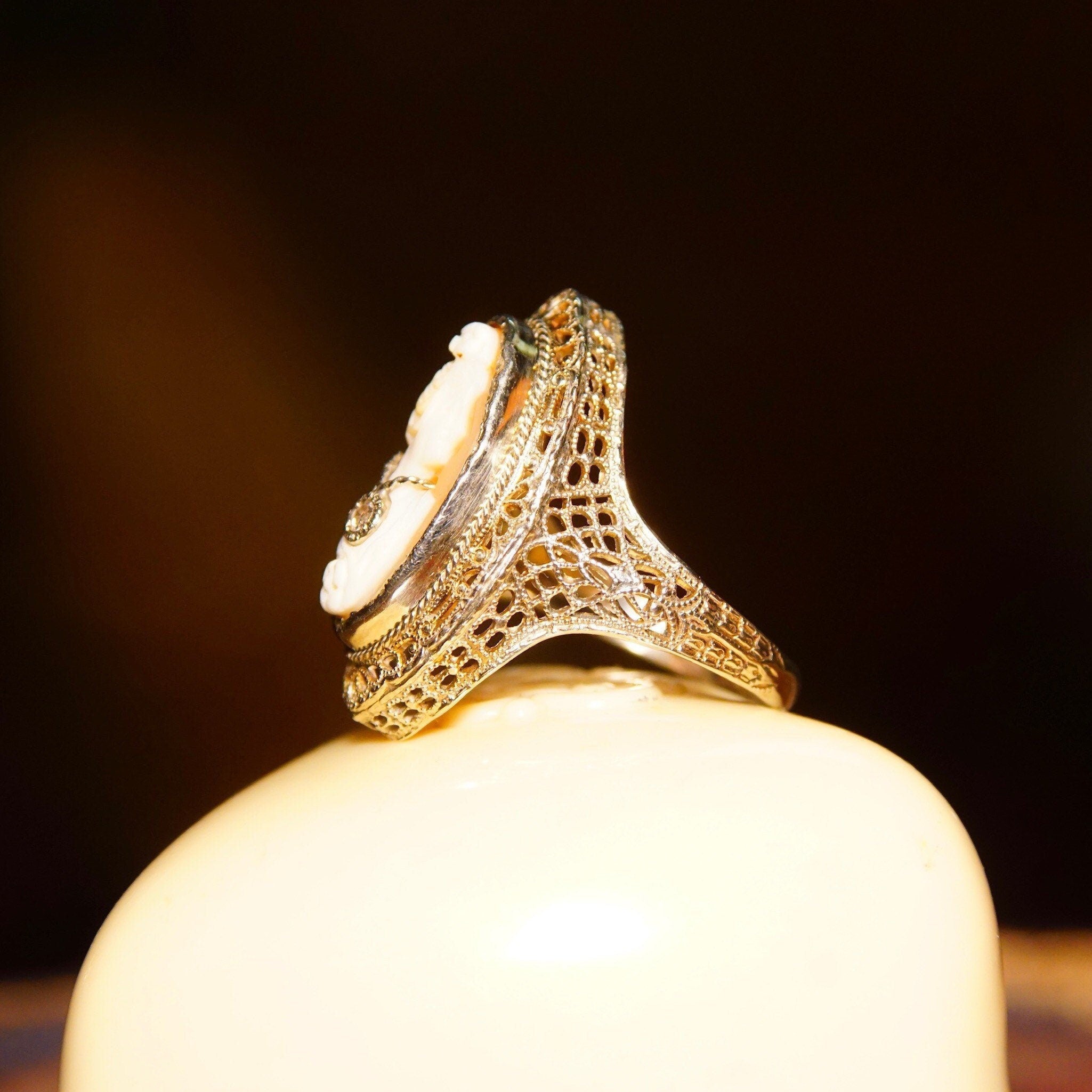 Antique 14K white gold filigree ring with carved shell cameo of a woman's profile wearing a diamond necklace, with additional diamond accents on the ring's ornate vintage setting, size 6 1/4 US by ESEMCO.