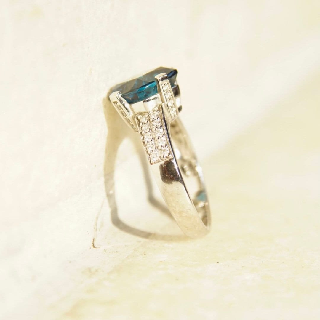 Vintage 14K white gold blue topaz cushion cut solitaire ring with diamond accents in cathedral setting, size 7.5 US