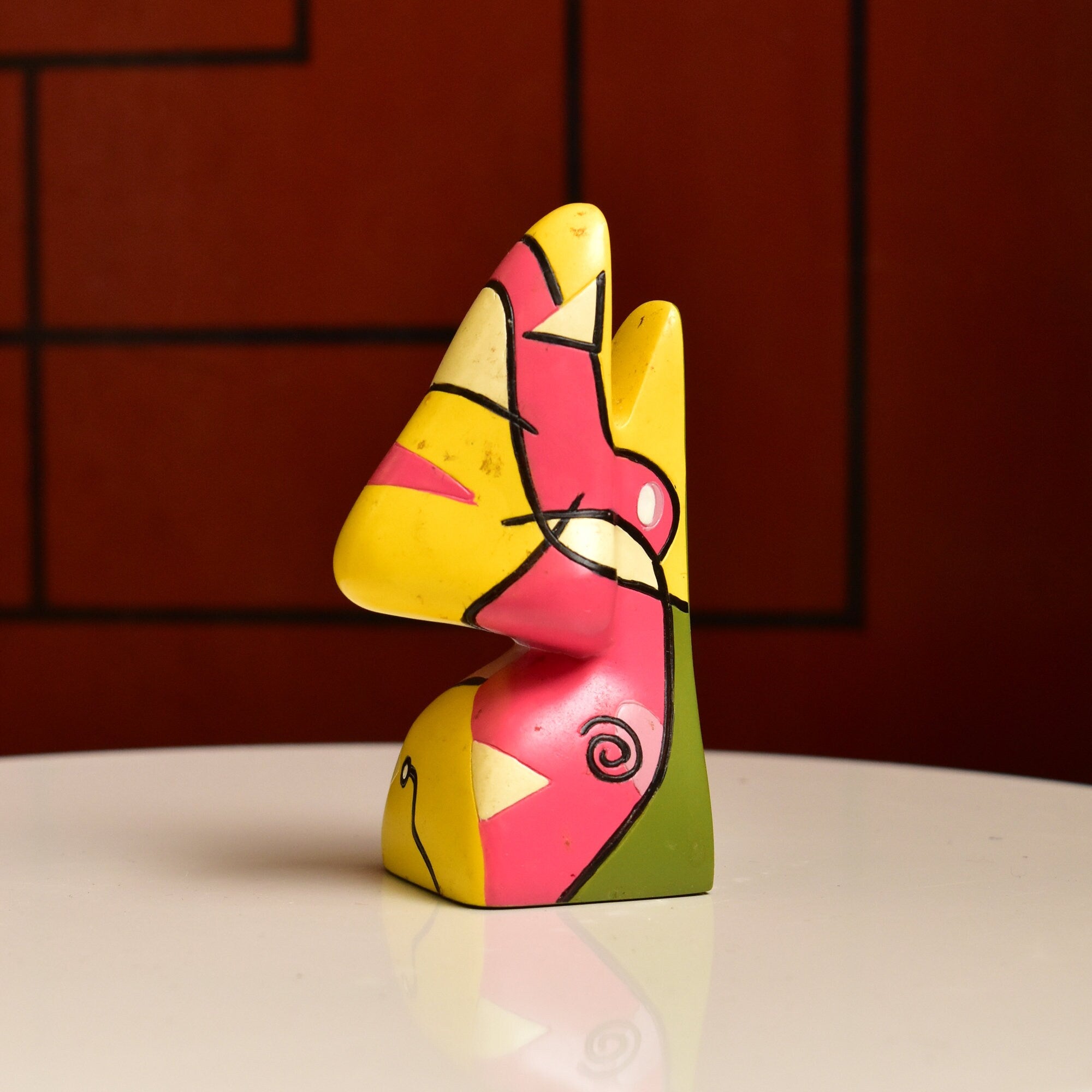 Colorful abstract resin eyeglass holder stand in the shape of a face with geometric features, measuring 3 3/4 inches high, vintage home decor accessory