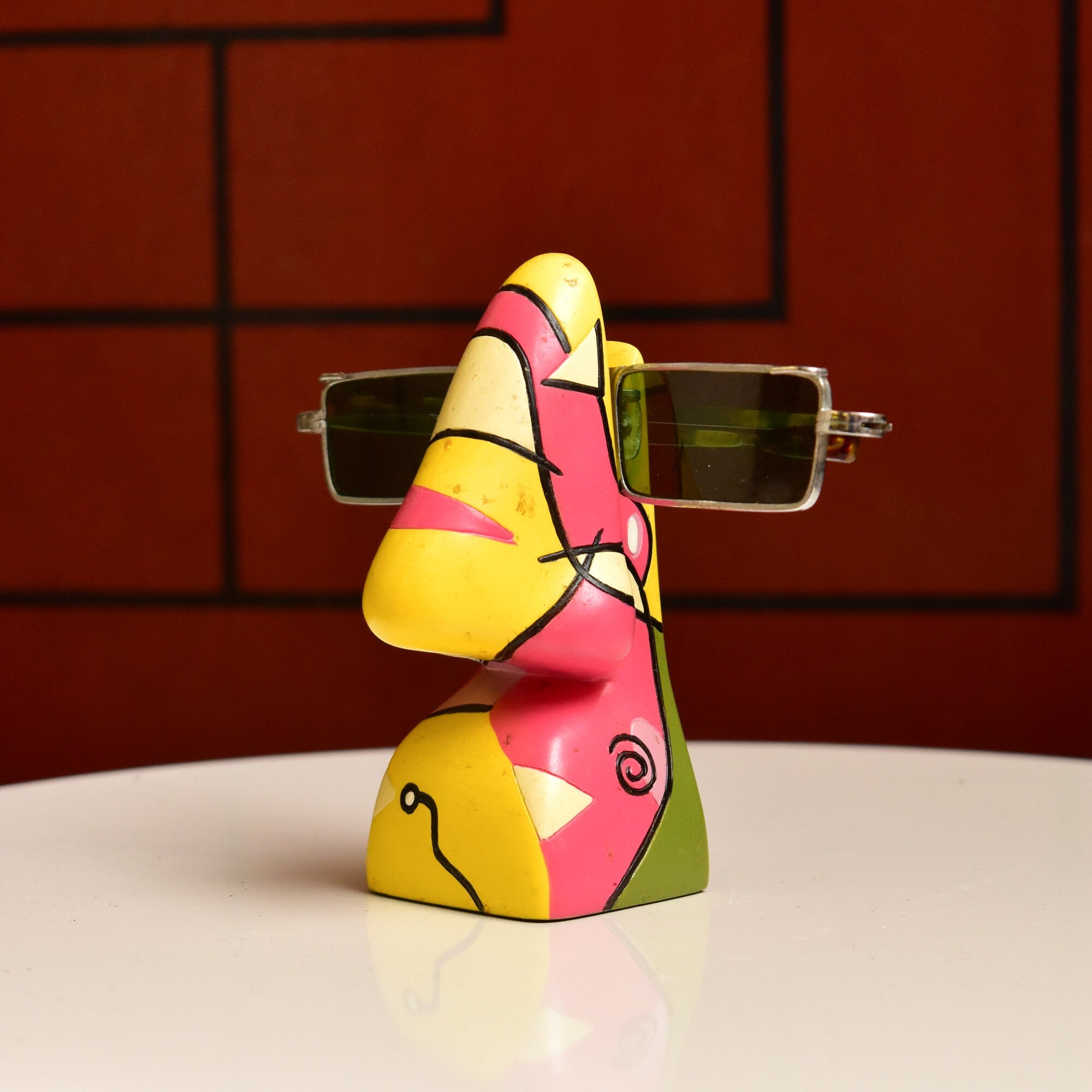 Colorful abstract resin eyeglass stand shaped like a human face with Picasso-style features, measuring 3 3/4 inches tall, for holding glasses as a unique vintage home decor accent piece.