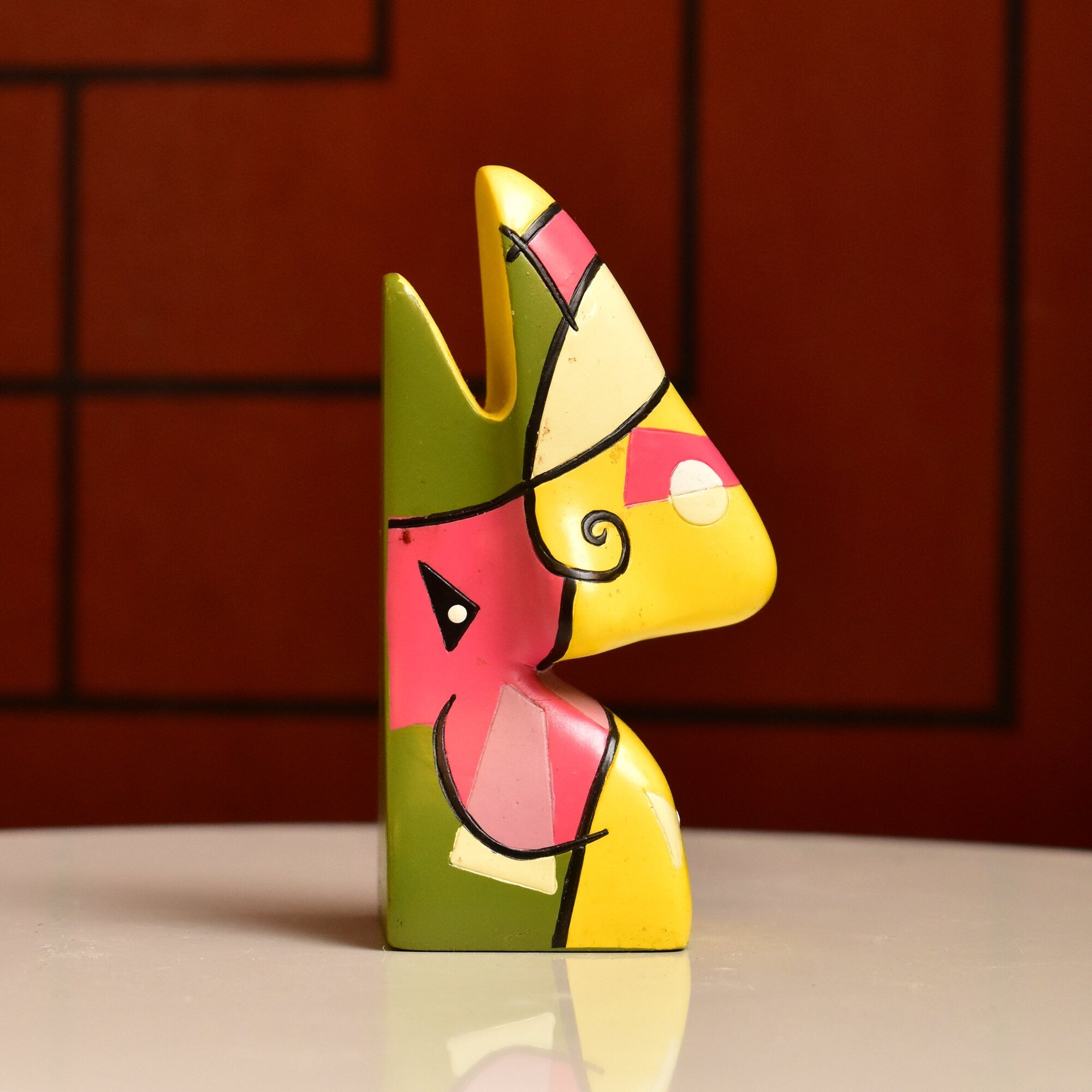 Colorful abstract resin eyeglass holder shaped like Picasso's face, with geometric shapes in yellow, green, red and black, measuring 3 3/4 inches tall, for vintage home decor.