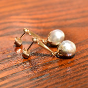 18K yellow gold baroque freshwater pearl dangle earrings with original pushbacks on wooden surface, estate jewelry