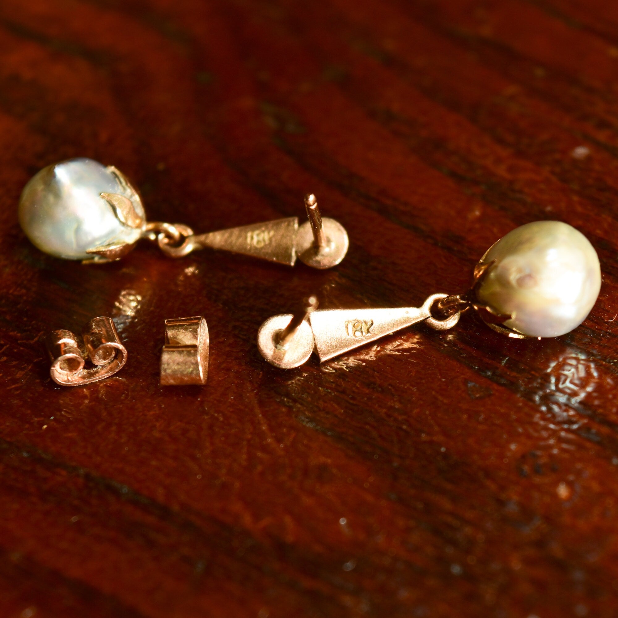 18K yellow gold baroque freshwater pearl dangle earrings with original pushbacks on wooden surface, estate jewelry