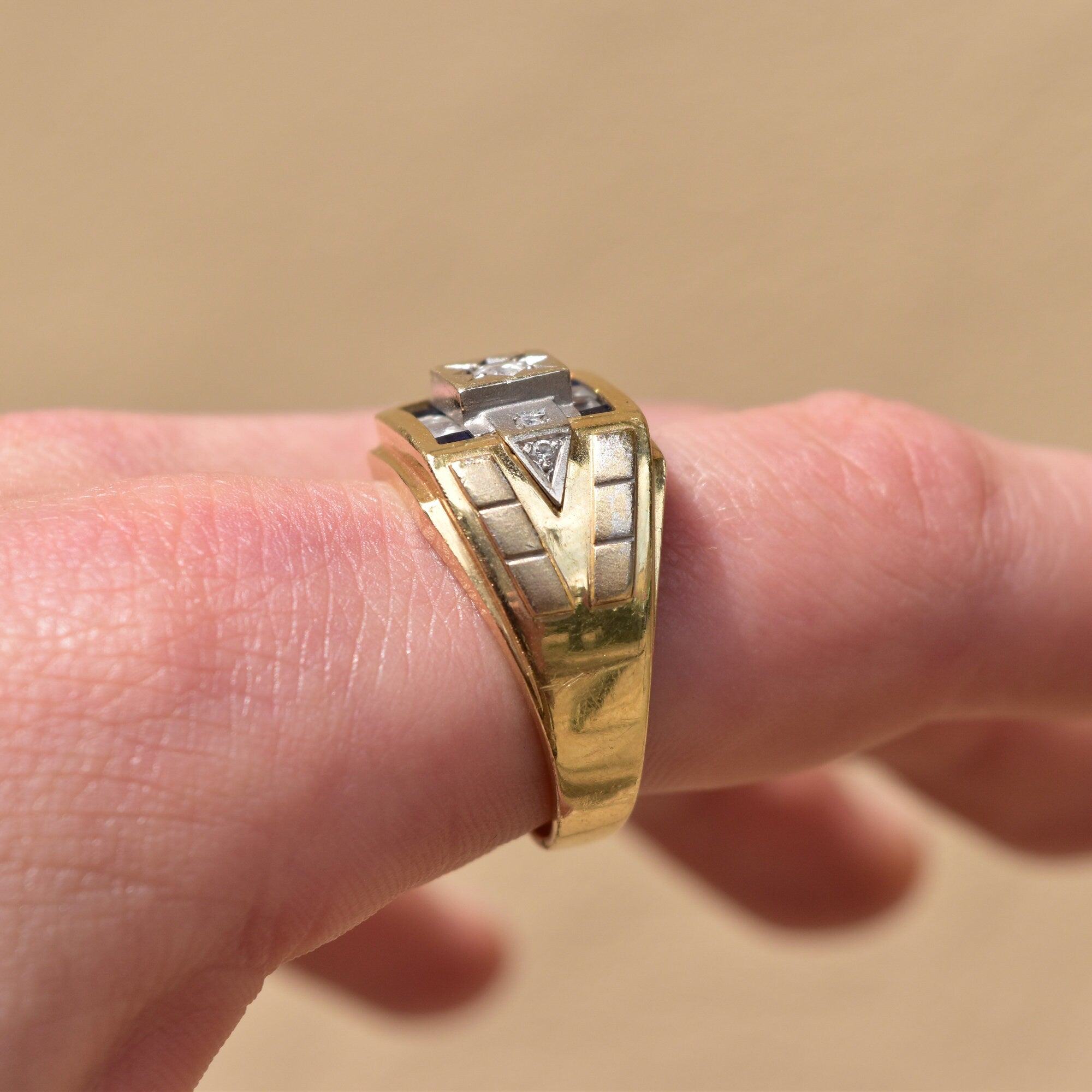 Two-tone 14K gold men's signet ring with diamond and sapphire in an engraved star setting, worn on finger, estate jewelry, size 12 US.