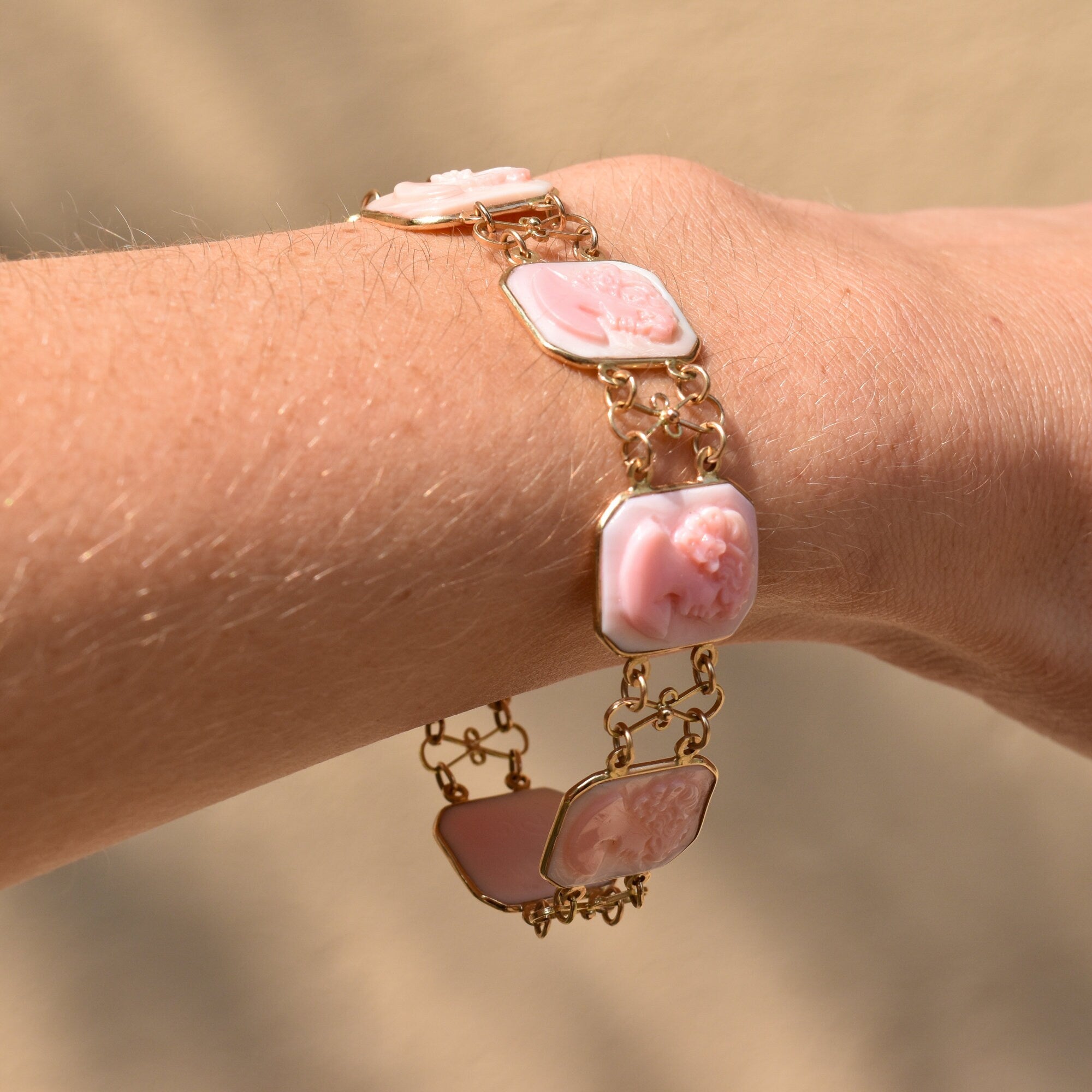 Italian 14K pink gold cameo link bracelet with square and oval links featuring carved shell cameos on the wrist against skin, estate jewelry signed M+M SCOGNAMIGLIO, measuring 7 1/4 inches long.