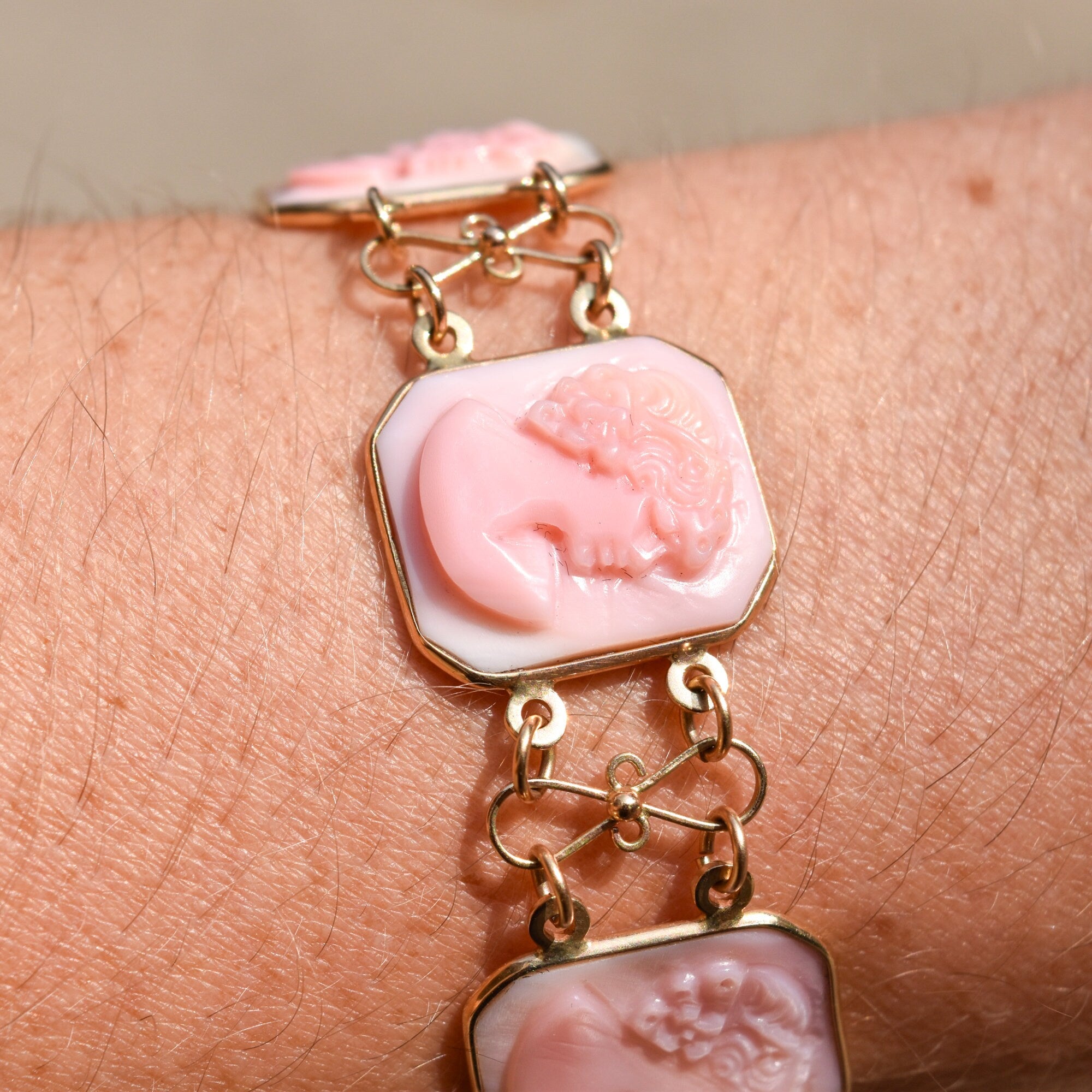 Antique Italian 14K gold pink shell cameo link bracelet with carved profiles on each link, signed by M+M SCOGNAMIGLIO, measuring 7 1/4 inches long.
