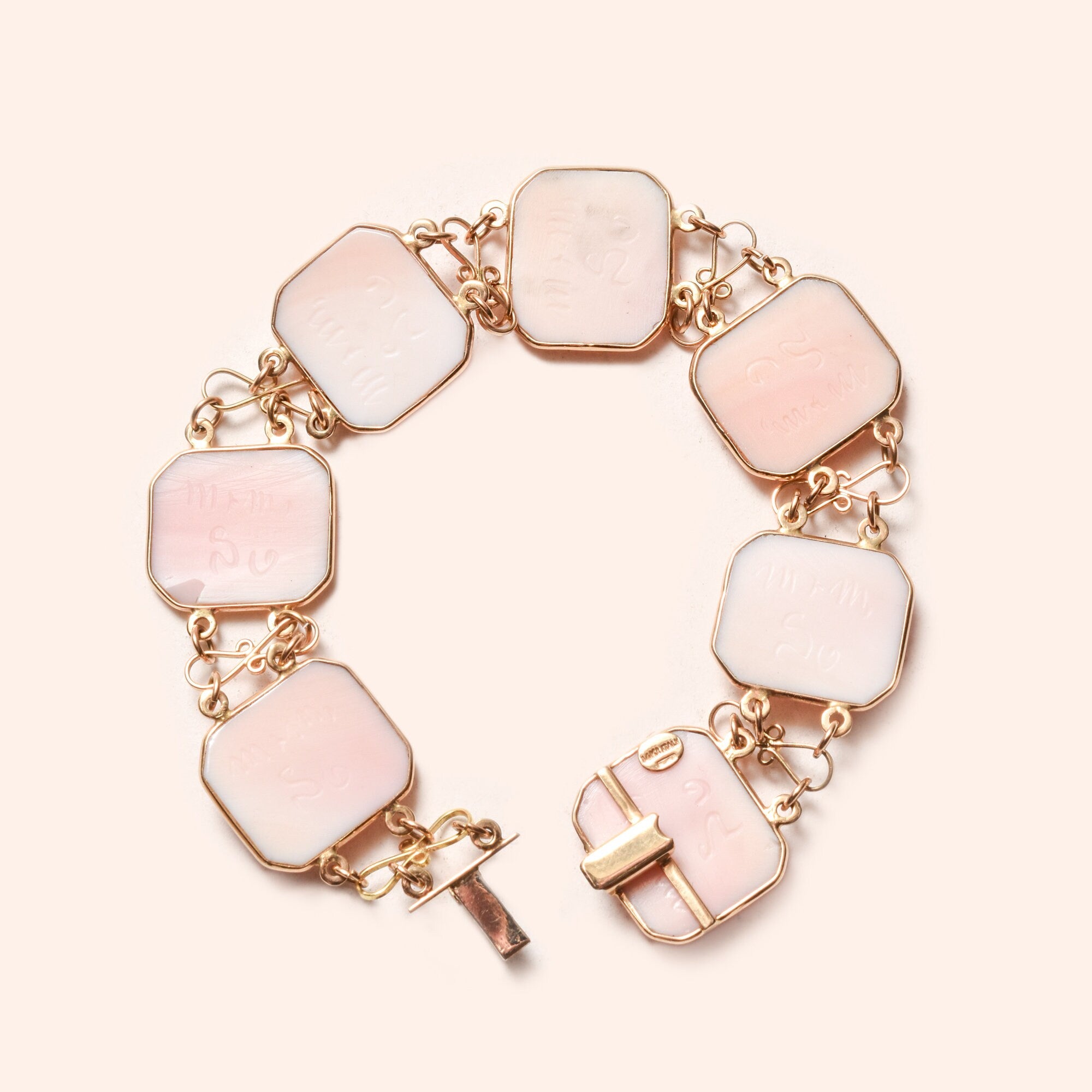Italian 14K gold pink cameo link bracelet with seven octagonal shaped cameo links connected by gold chains, signed by M+M SCOGNAMIGLIO, estate jewelry measuring 7 1/4 inches in length.