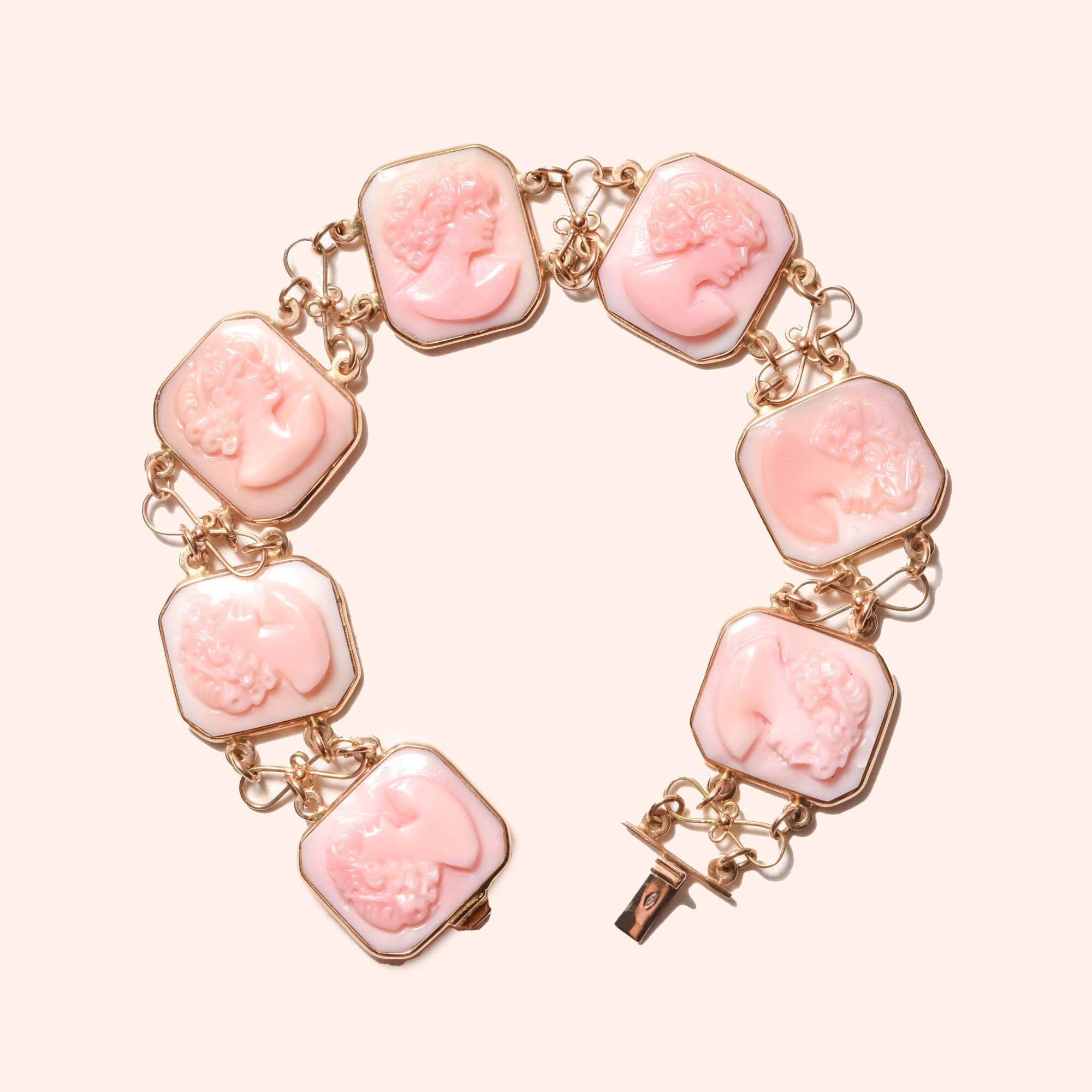Italian 14K pink gold cameo link bracelet featuring seven carved shell cameo plaques depicting feminine silhouettes, connected by decorative gold links. Estate jewelry piece signed by M+M SCOGNAMIGLIO, measuring 7 1/4 inches in length.