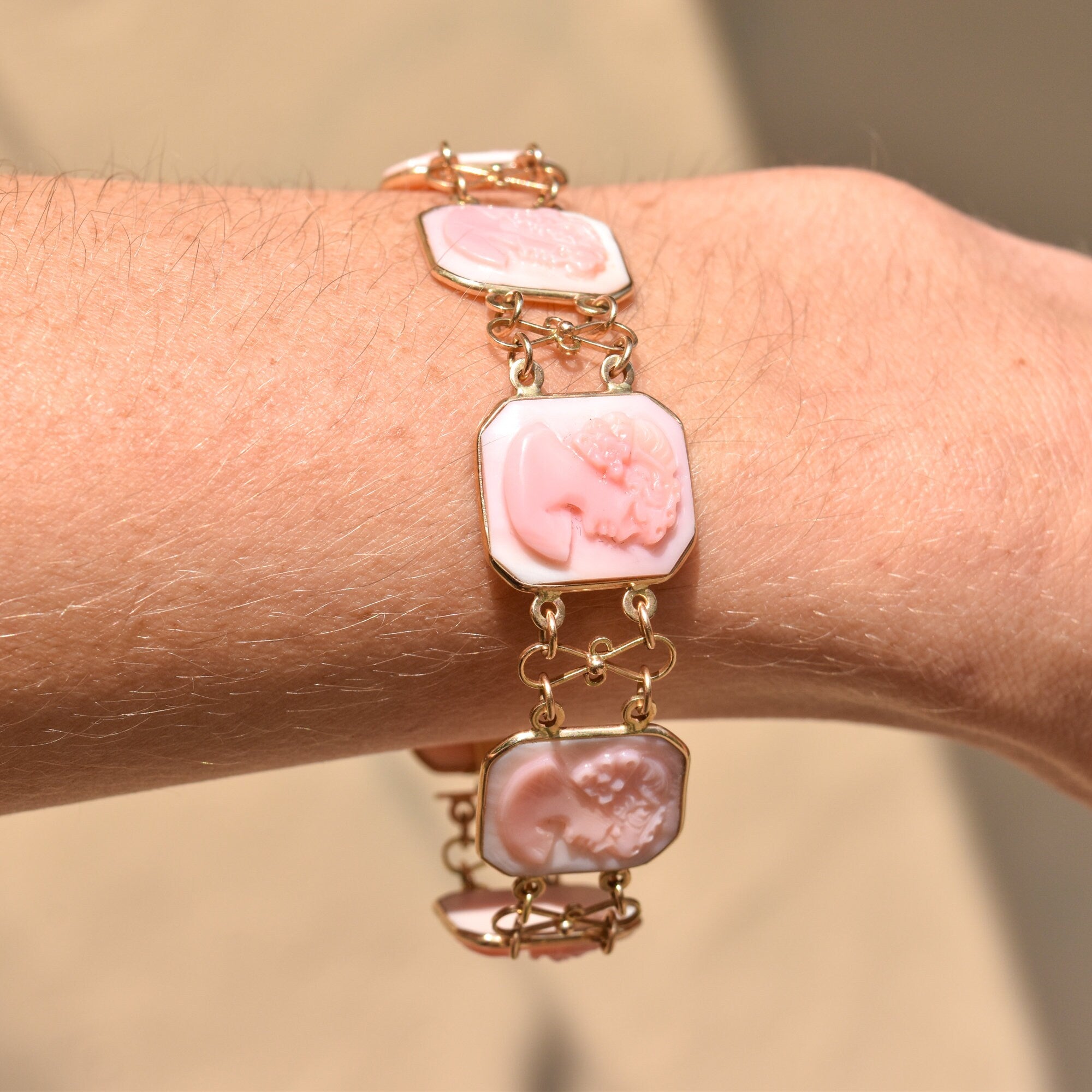 Antique 14K rose gold Italian cameo link bracelet featuring carved pink conch shell cameos with floral motifs, signed by M+M SCOGNAMIGLIO. The bracelet measures 7 1/4 inches long and is an estate jewelry piece.