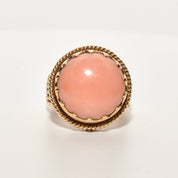 Estate angel skin coral cocktail ring in 18K yellow gold with a woven band, size 6.25 US, displayed on a white background.