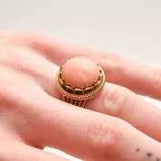 Estate Angel Skin Coral Cocktail Ring in 18K yellow gold with woven band, showcased on a finger, size 6.25 US.