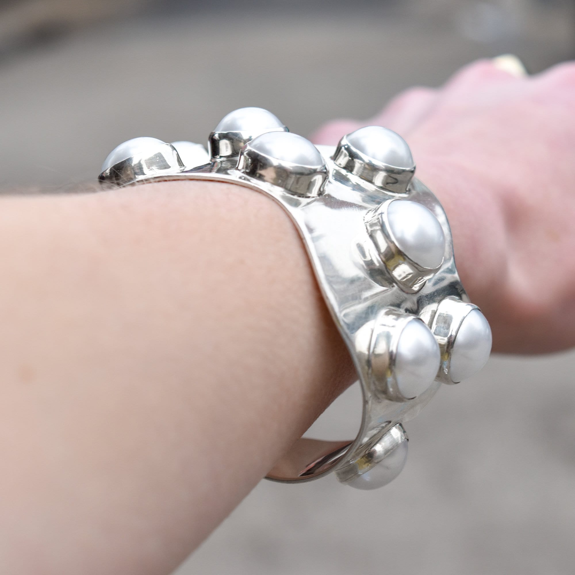 Sterling silver TAXCO modernist mabe pearl cuff bracelet with wide wavy design on wrist, 5.75 inch statement jewelry piece